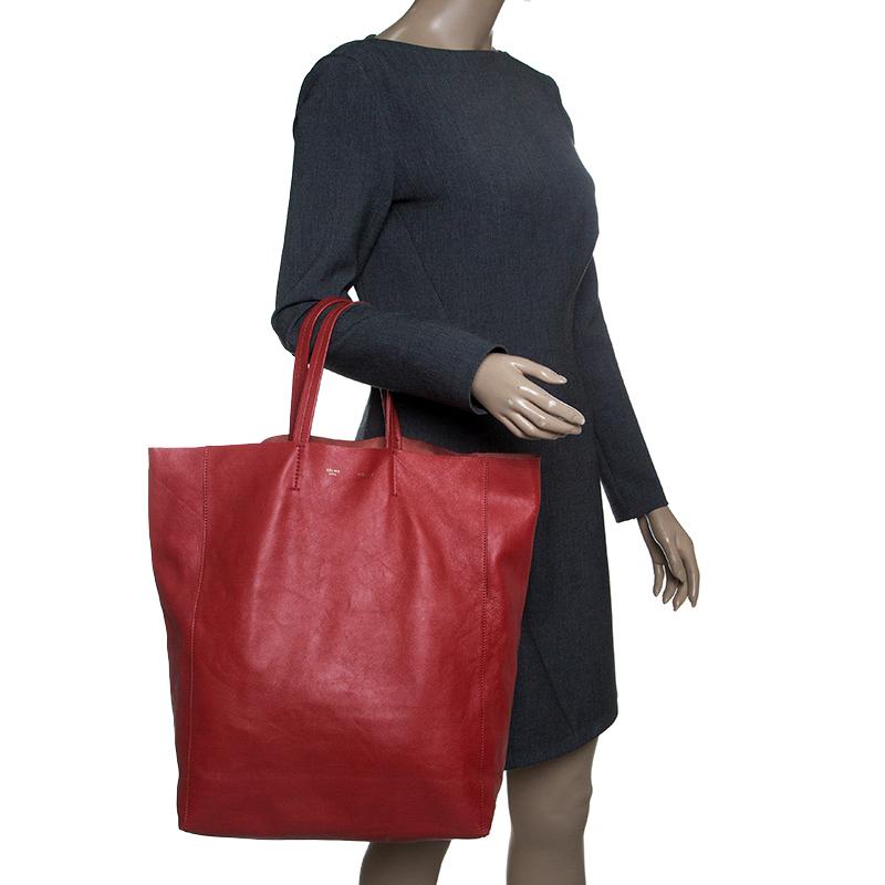 An elegant tote designed by Celine, this Cabas bag is a wonderful mix of fashion and function. Beautifully crafted with red leather into a minimalist yet utilitarian design, the tote features two flat handles and a roomy interior lined with leather