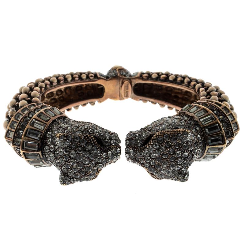 Beautifully sculpted from gold-tone metal, this Roberto Cavalli bangle is a choice of a modern woman. It carries an intricate design of studs and two panther heads embellished with crystals. This bracelet is classy and will be a fine outfit