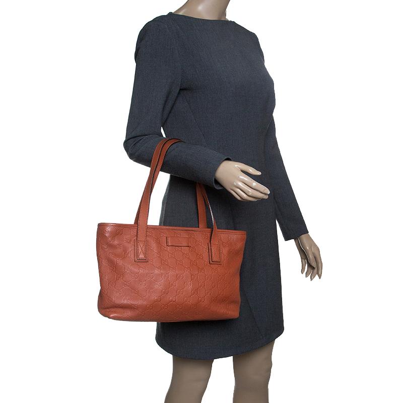 Featuring two handles at the top and a sleek orange shade, this Gucci tote exudes just the right amount of sophistication. The Guccissima leather bag also features a capacious nylon compartment to house all your essentials. This piece is definitely