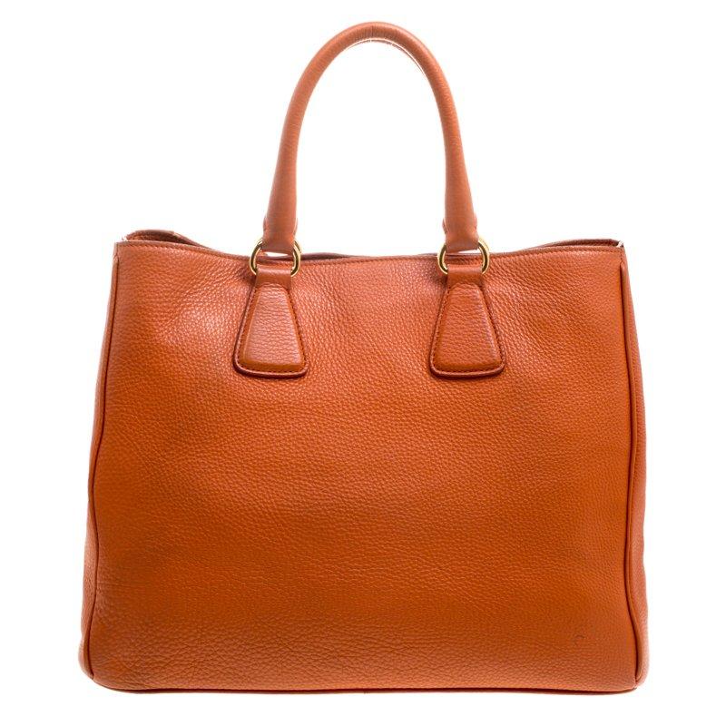 This Shopper tote from Prada will undoubtedly be your best buy! Orange in colour, the leather bag features a simple design. It comes with two top handles, protective metal feet, a leather tag and a nylon lined interior that houses slip pockets. You