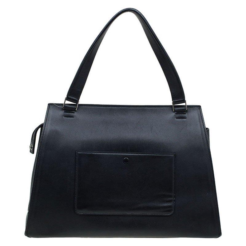 This trapezium shaped edge tote is from the house of Celine. The minimal design is crafted from black and yellow leather and calf hair. It features a flat handle, zip pocket at the front and a buttoned pocket at the rear. The leather lined interior