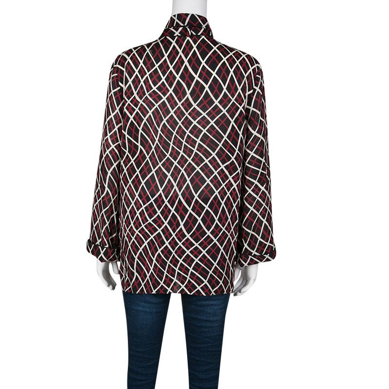 The white and red abstract print adorning this black blouse is the most striking feature of this Gucci creation. It is cut from 100% silk in a loose structure with stylish tie detail on the neck. Completed with long sleeves, it can be tucked into