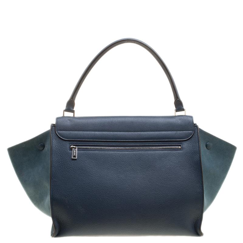 Featuring a chic, yet luxurious style, this Celine bag is distinctive. Crafted from leather and suede, this tote features signature flappy wings, silver-tone hardware and a zip pocket at the rear. The front flap of the blue tote opens to a spacious