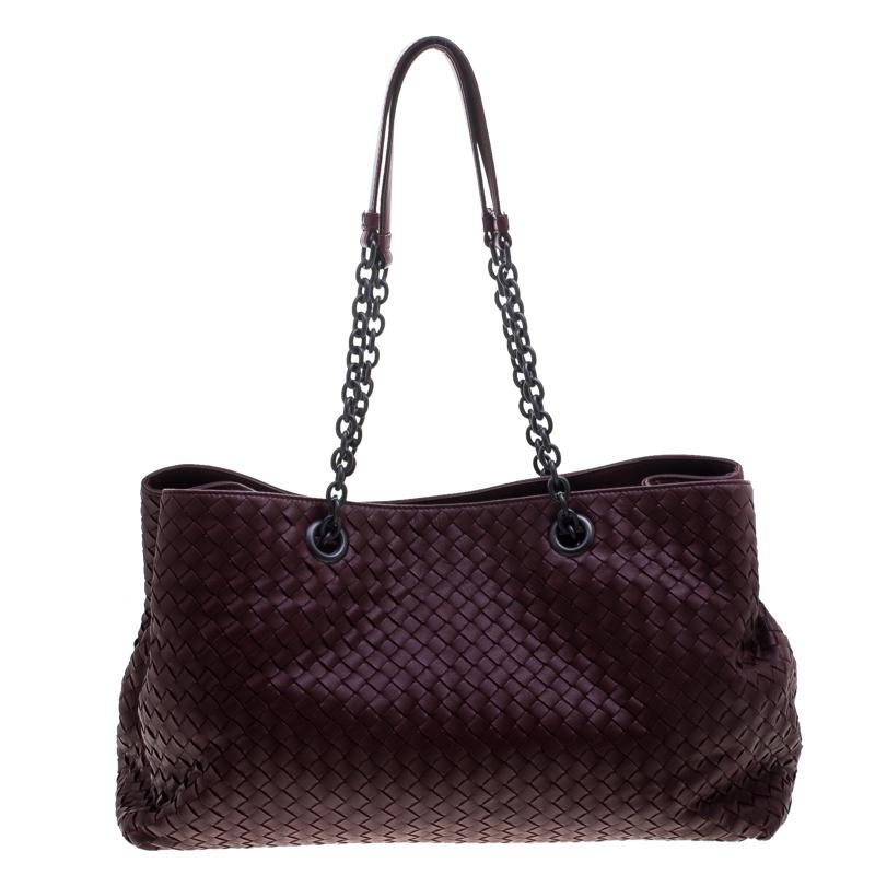 This Bottega Veneta tote is a creation that brings joy to one's sight! It has been beautifully crafted from leather and designed in their signature Intrecciato pattern while being held by double chains. The bag is also equipped with snap buttons