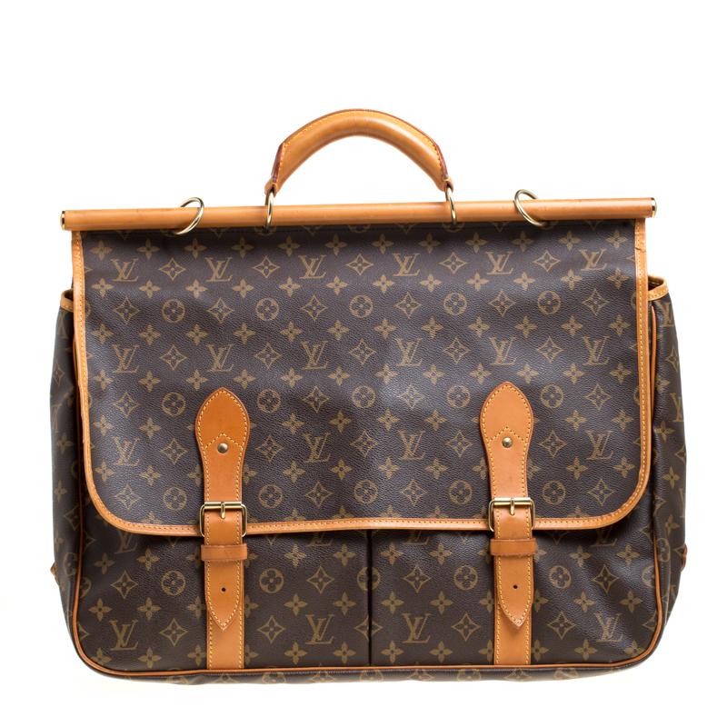 This practical Louis Vuitton Sac Chasse Hunting bag has been crafted from the brown monogram coated canvas. It features tan leather trims, a rolled handle on structured top along with an adjustable shoulder strap. The size is adjustable and