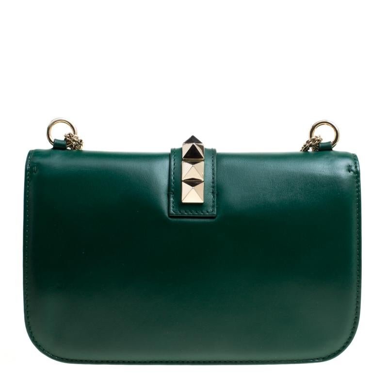 If you are looking for a bag with a blend of modern style and class, this Valentino shoulder bag is the answer. The striking green bag comes with the iconic Rockstud trim. Made in Italy, the bag is crafted from leather and has a fabric lined