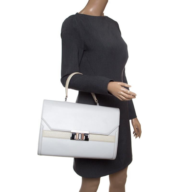 Hints of class and luxury define this Oscar de la Renta bag. Designed in a structured silhouette, this bag is crafted in white and cream leather and arrives with a classic top handle that will tote effortlessly over your arms. The sizeable piece
