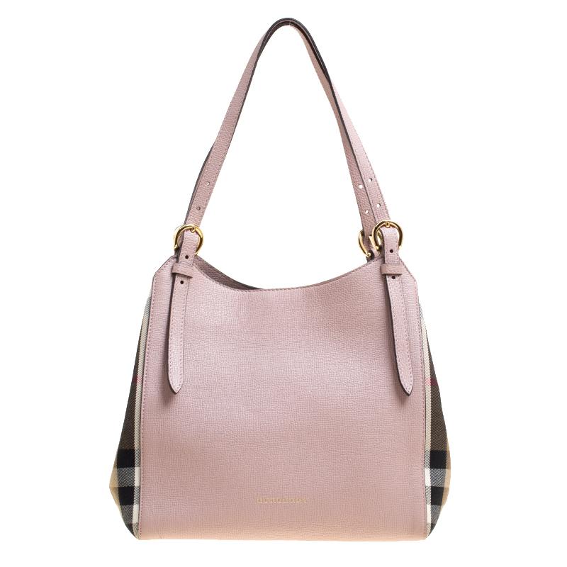This Canterbury tote from Burberry is crafted from lilac leather with their signature House check adorning the sides. It comes with dual flat handles detailed with buckles, protective metal feet at the base and a canvas-lined interior that can hold