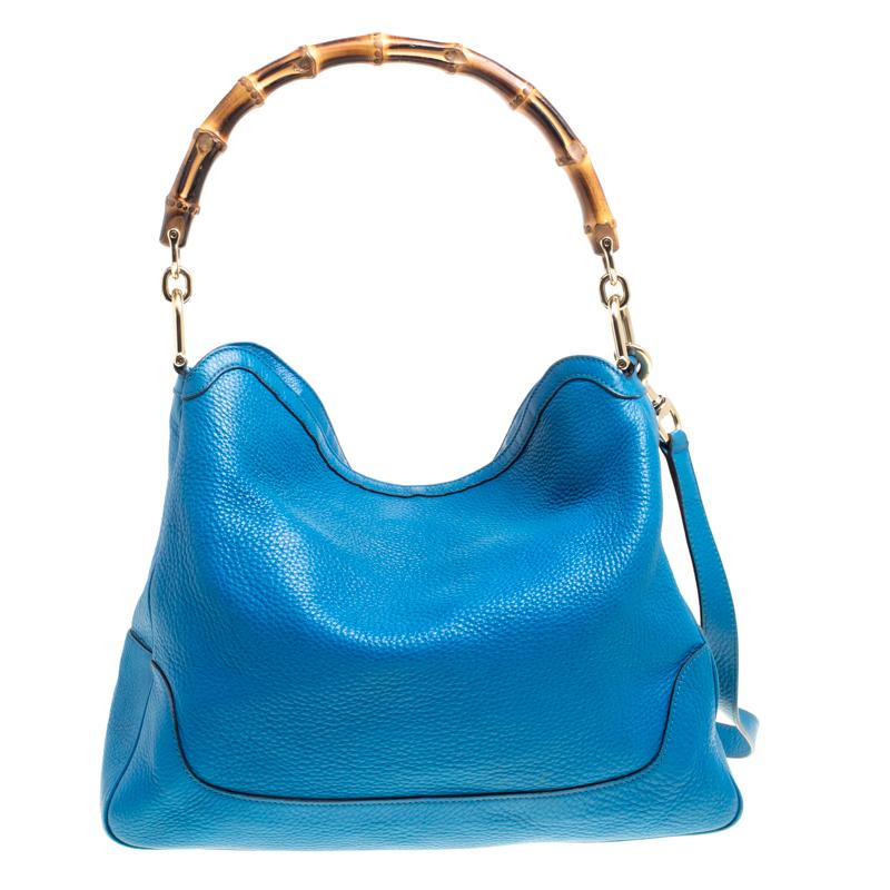 Invest in this timeless creation from the house of Gucci. Sophisticated and elegant, this blue tote is made from pebbled leather into a slouchy and relaxed shape. This stylish bag comes with a bamboo handle and a detachable shoulder strap for