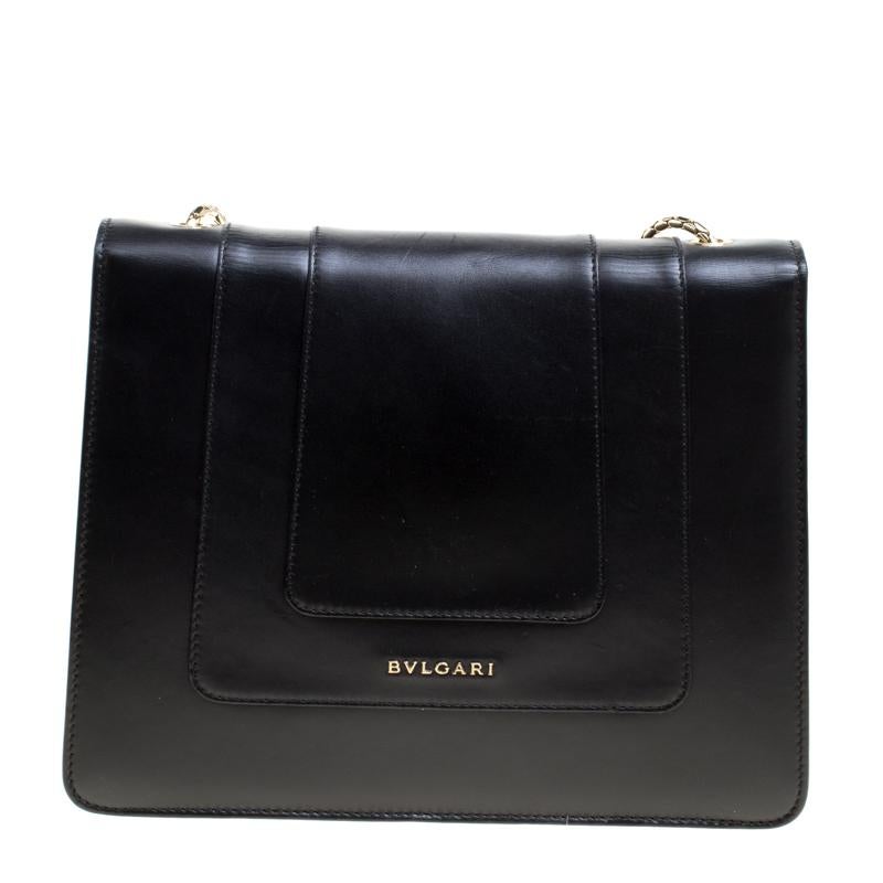 This stunning Bvlgari creation is crafted from leather in a breathtaking black hue. The shoulder bag is styled with a flap that has the iconic Serpenti head closure. The bag comes with a well-sized fabric lined interior that houses a slip and a zip