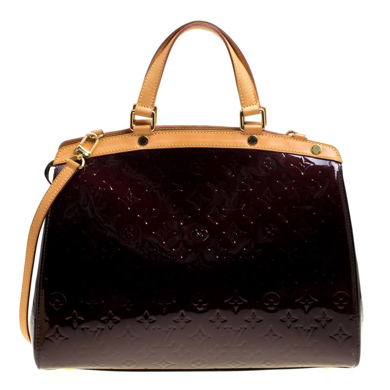 The feminine shape of Louis Vuitton's Brea is inspired by the doctor's bag. Crafted from their signature Vernis leather in a grand shade, the bag has a perfect finish. The fabric-lined interior is spacious and it is secured by a zipper. The bag