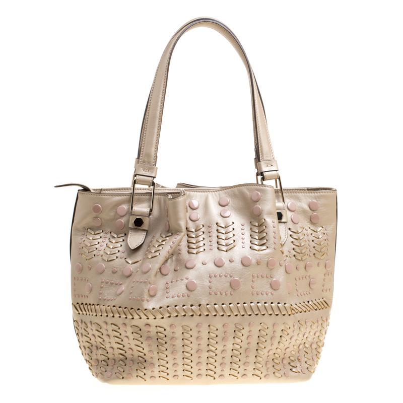 Enchanting in a contemporary design is this Flower tote from Tod's. This metallic beige bag has been meticulously crafted from leather, detailed with studs and equipped with a spacious nylon interior that will dutifully hold all your essentials.
