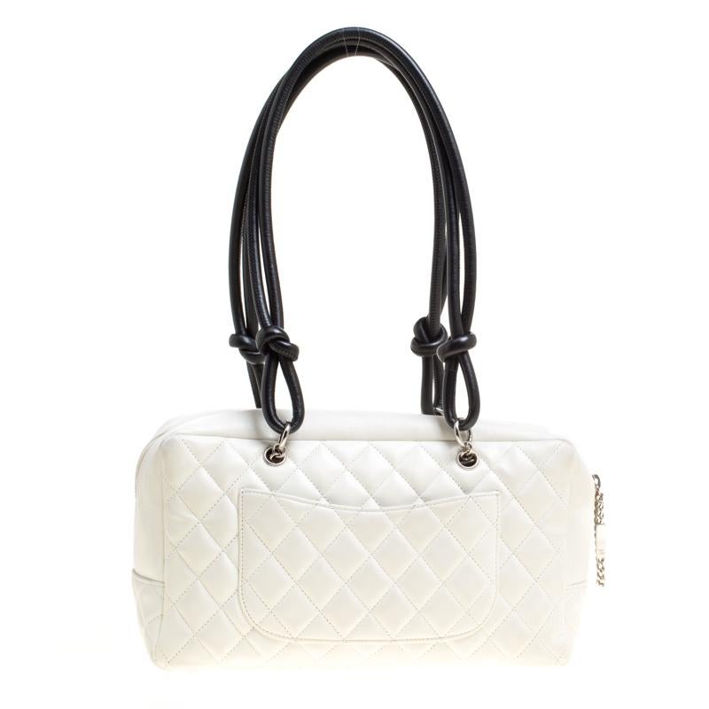 Radiate with elegance when you swing this Bowler bag from Chanel. Beautifully crafted from leather in white, and designed with the CC logo on the side, this bag is a beauty. A zip closure secures a spacious fabric interior and the bag is held by two