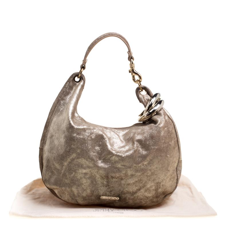 Shimmer your way through the day with this fun Jimmy Choo hobo. Made from leather, its shimmering gold exterior is designed with gold-tone brand detailing on the front. The handle is designed with gold-tone hardware complementing its the hue,