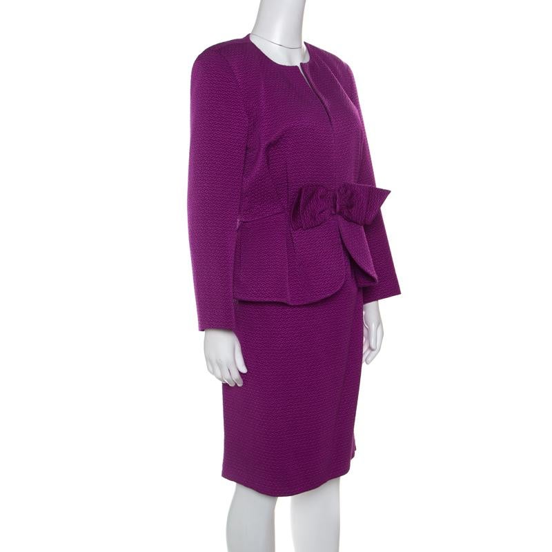 Trust Carolina Herrera to bring out something unique and here is this jacquard skirt suit to impress you. This purple creation is made of a wool and silk blend and features a chic bow detailing at the waist. While the blazer comes with a round