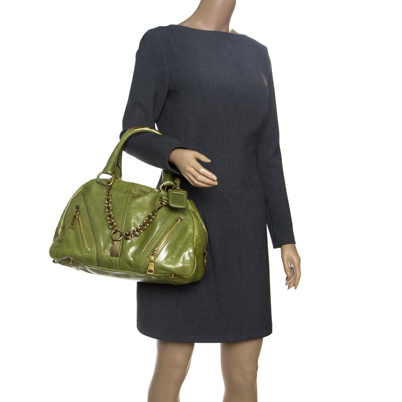 This Vitello Shine bowler bag from Prada is not only artistic in design but also high on style. Crafted from leather, the green bag features a contemporary and edgy silhouette. It flaunts gold-tone interlocking chain detailing at the front, multiple