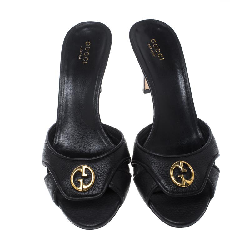 These black slide sandals by Gucci are classic. Crafted from leather, they feature the signature GG logo on the front in gold-tone hardware along with leather lined insoles that carry brand labelling. They are elevated on 8 cm tall heels. These
