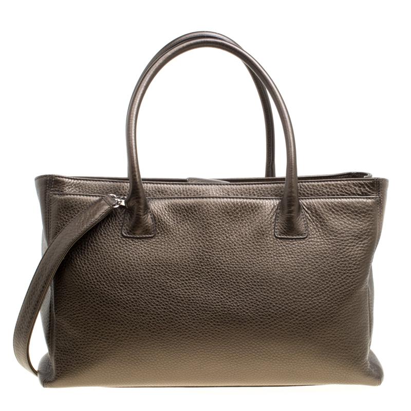 Chanel brings to you this fabulous Cerf Executive Tote to ace the formal work setting. This khaki creation is crafted from leather and features dual handles and a shoulder strap. It flaunts the signature CC logo at the front and has a spacious