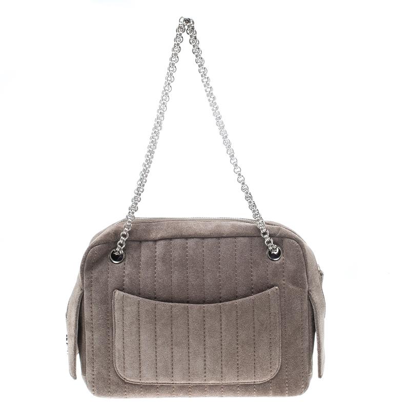 Crafted from suede, this grey piece from Chanel is sure to make a standout addition to your collection. The bag features a vertical stripe stitch detailing and interlocking chain shoulder straps. It flaunts a front and back pocket and the top zip