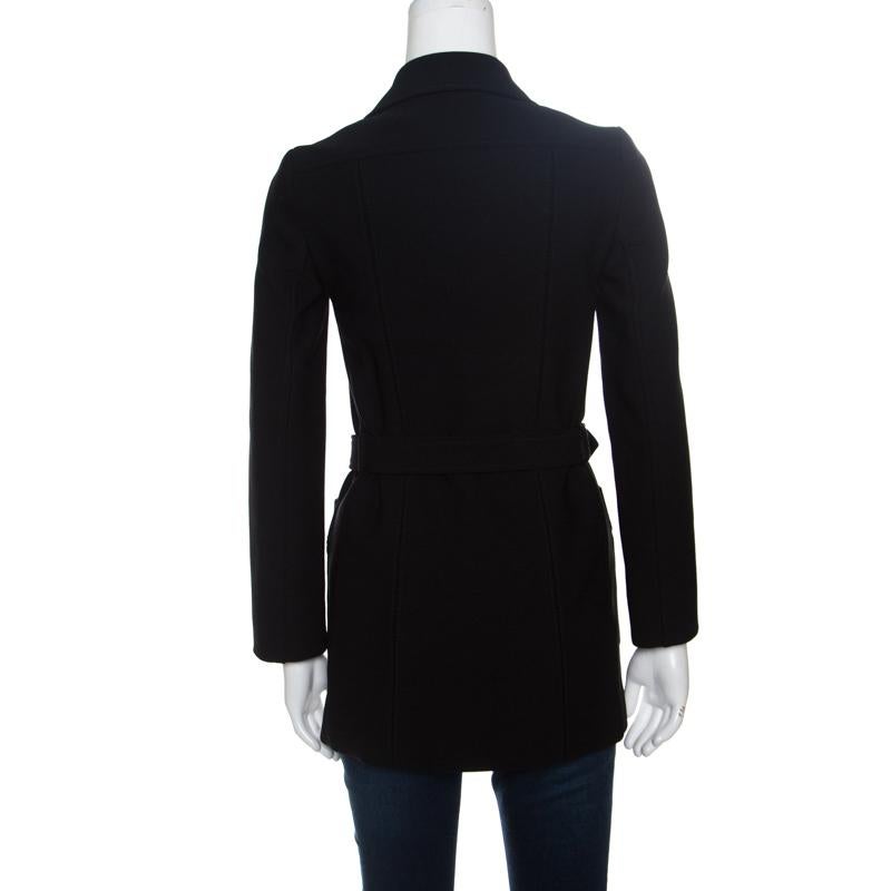 A perfect choice to make a fashion statement, this black coat from Prada is sure to set hearts racing with its fabulous design and style. The coat is made of a blend of fabrics and features a collared neckline, front button fastenings and a buckled