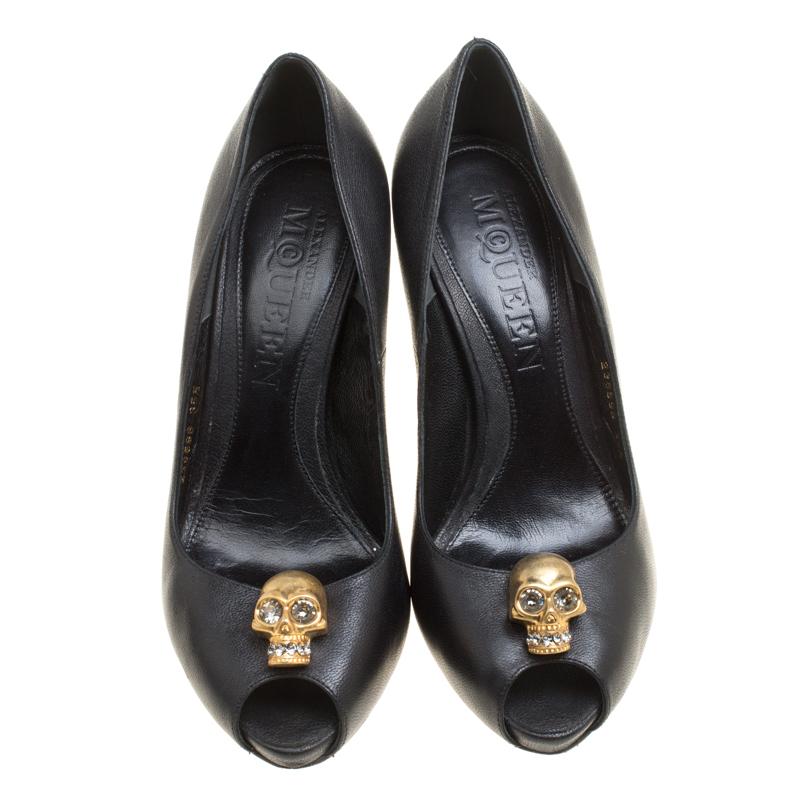 Breathtaking and whimsical, these pumps from Alexander McQueen are here to enchant you and make you fall in love with them. These black pumps are crafted from leather and feature a peep toe silhouette. They flaunt a gold-tone crystal embellished