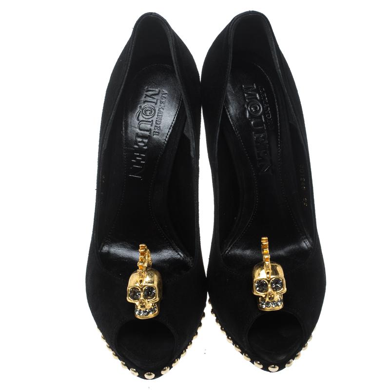 Breathtaking and whimsical, these pumps from Alexander McQueen are here to enchant you and make you fall in love with them. These black pumps are crafted from suede and feature a peep toe silhouette. They flaunt a gold-tone embellished skull motif