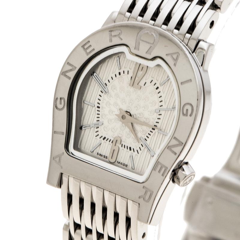 Diese Uhr aus dem Hause Aigner ist in einen Edelstahlkörper mit einem Gehäusedurchmesser von 24mm gegossen. Es verfügt über das logoförmige Zifferblatt des Hauses mit dem auf der Lünette eingravierten Markennamen. Es verfügt über ein weißes