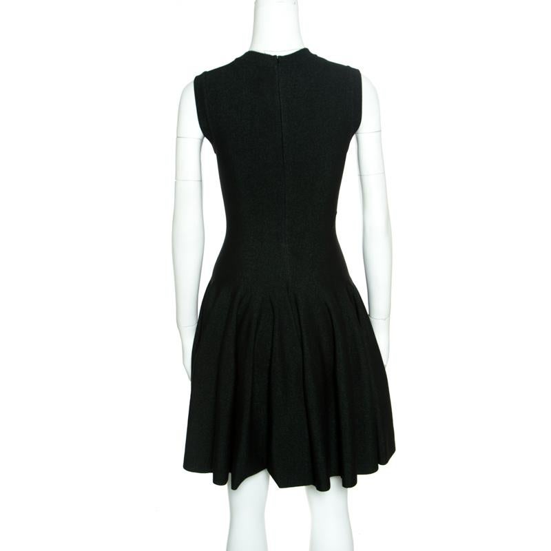 Gorgeous in shape and high on appeal, this dress is from the label of Alaia. It is tailored from quality fabrics in black and green lurex knits and designed with a V neckline and a fit and flare style. This creation will look perfect with statement
