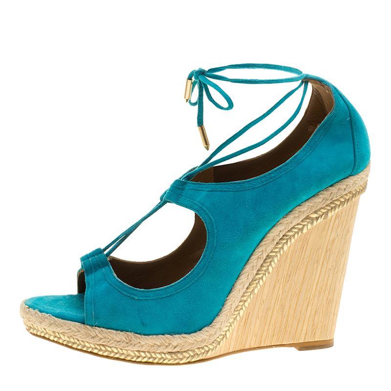 To perfectly complement your summer looks come these beautifully designed Aquazurra Christie sandals. They are crafted in turquoise blue coloured suede featuring a cutout topline detailed with slender laces. The pair is set on a wooden wedge heel