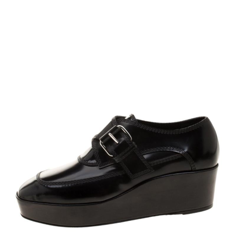 Balenciaga is one of the leading luxury brands with a strong fashion-forward feel. These black patent leather loafers come with platform sole, monk straps featuring silver-tone buckles, and triple stitching. Comfortable and extremely stylish in