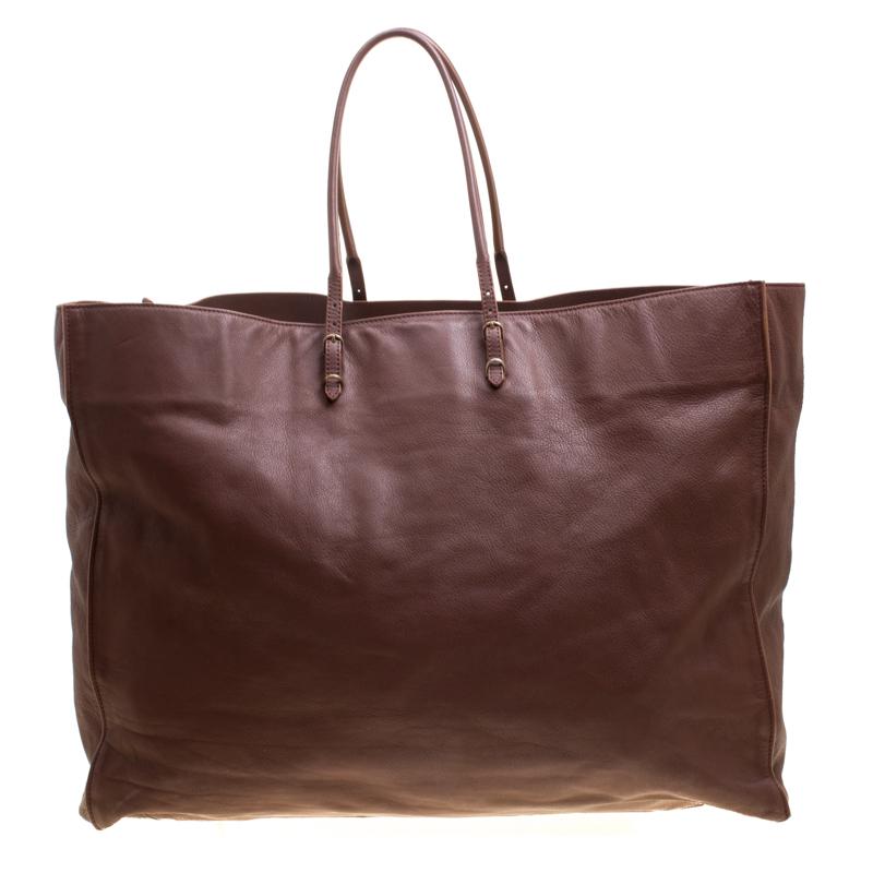 Minimal in design but high on style and craftsmanship, this brown Papier A3 tote from Balenciaga smoothly blends luxury with practical fashion. It comes crafted from leather and styled with a front zip pocket, buckles and a detachable mirror. But it