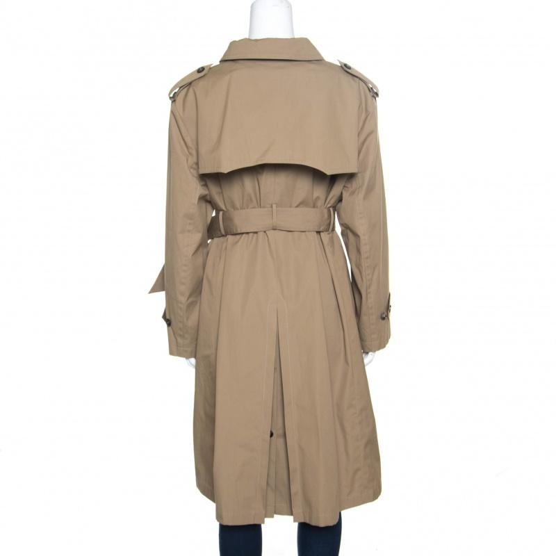 You'll surely find reasons to wear this fabulous trench coat from Balenciaga. The camel brown coat is made of 100% cotton and features a chic silhouette. It flaunts wide collars, epaulettes, a double breasted design with front button fastenings, a