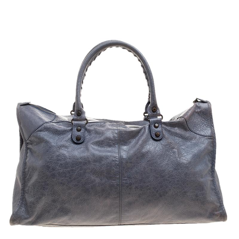 This Balenciaga RH work tote is perfect for everyday use. Crafted from leather in a gorgeous Jacinthe hue, the bag has a feminine silhouette with two top handles and gold-tone hardware. The zipper closure opens to a fabric-lined interior and the bag