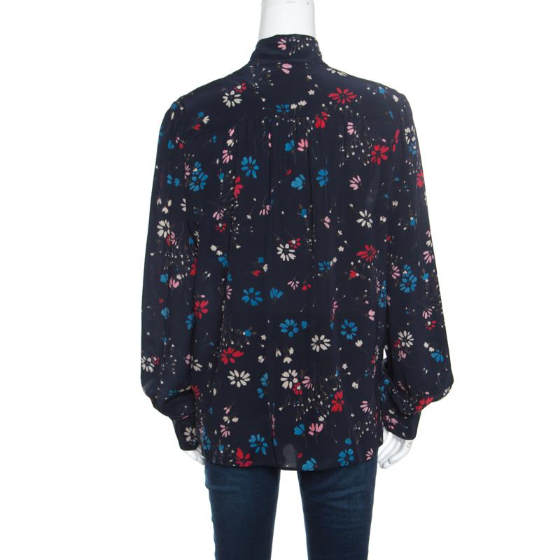Don a feminine style with this blouse from the house of Balenciaga. Designed in a simple structure with a tie detail at the neckline and cuffs, the blouse, crafted in silk, carries a pretty navy blue hue and is adorned with floral prints all over.