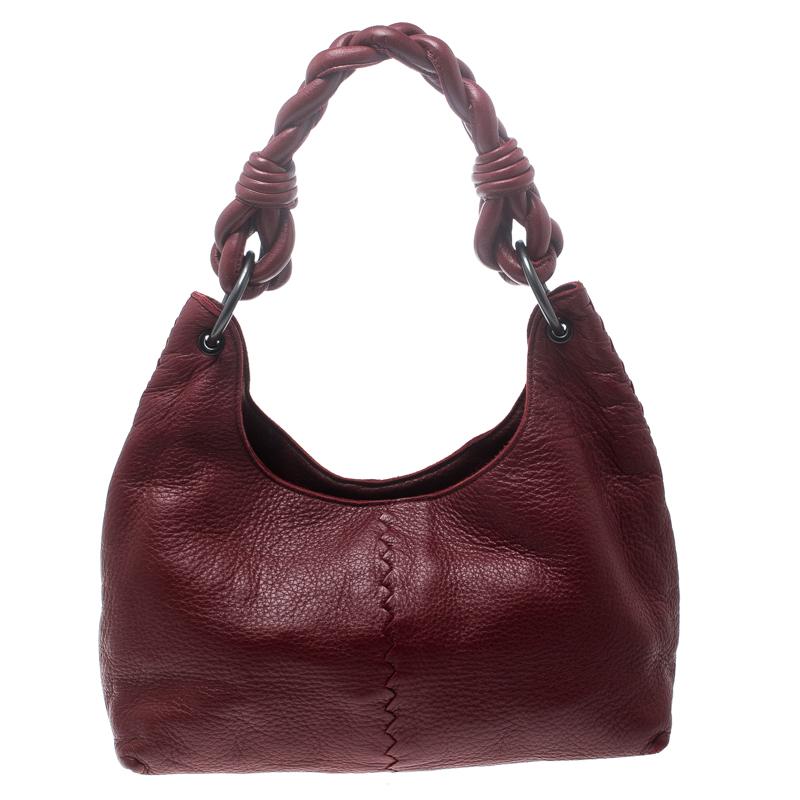 You will always find the time and occasion to pair this stunning Bottega Veneta piece with a daytime look. Crafted in red leather, this hobo features a black tone zipper closure at the top along with the braided top handle and a spacious interior to