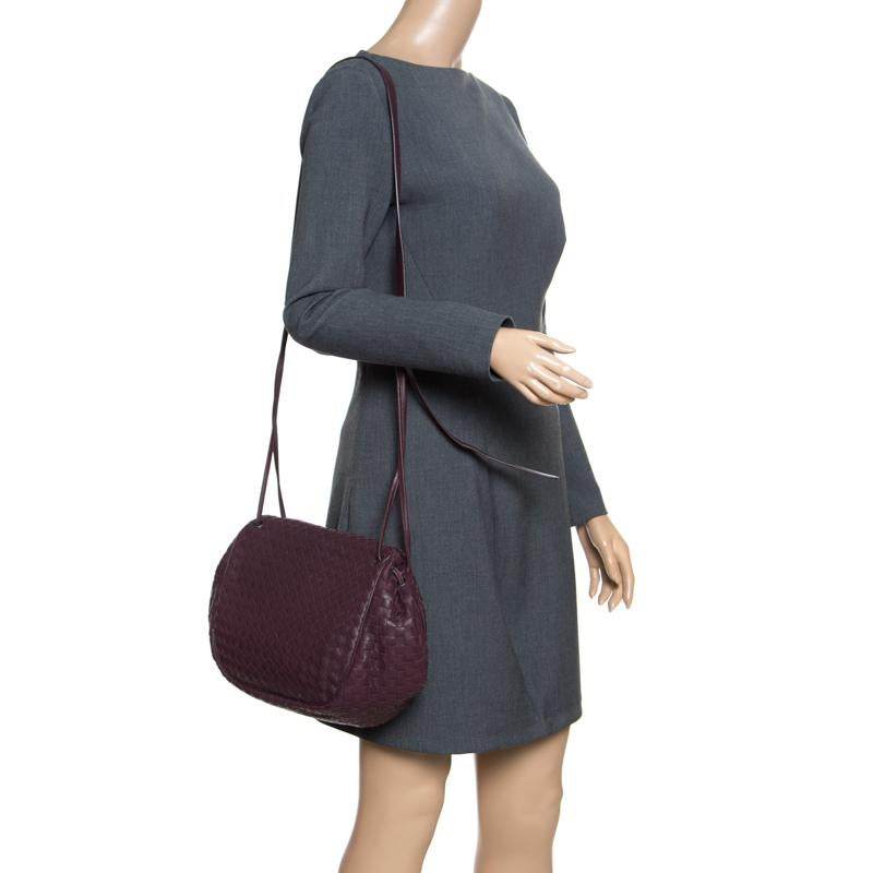 Versatile and practical, this crossbody bag from Bottega Veneta is absolutely delightful. The burgundy bag is crafted from leather and features the signature Intrecciato pattern all over it which is unique to the brand. It flaunts an adjustable
