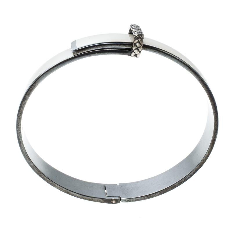To offer a great look, accessorise yourself with this sturdy metallic bracelet designed by Bottega Veneta. This is crafted from silver and layered with brightly hued enamel over it which depicts a belt-like construction. This sleek arm-piece can be