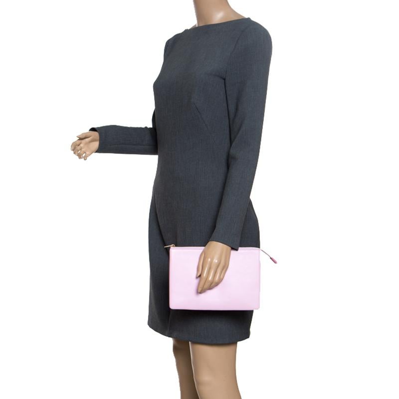 How cute and stylish does this clutch from Celine look! The lilac and orange clutch is crafted from leather and features the brand name on the front. It has a top zipper that opens to a leather lined interior that is spacious enough to hold all your