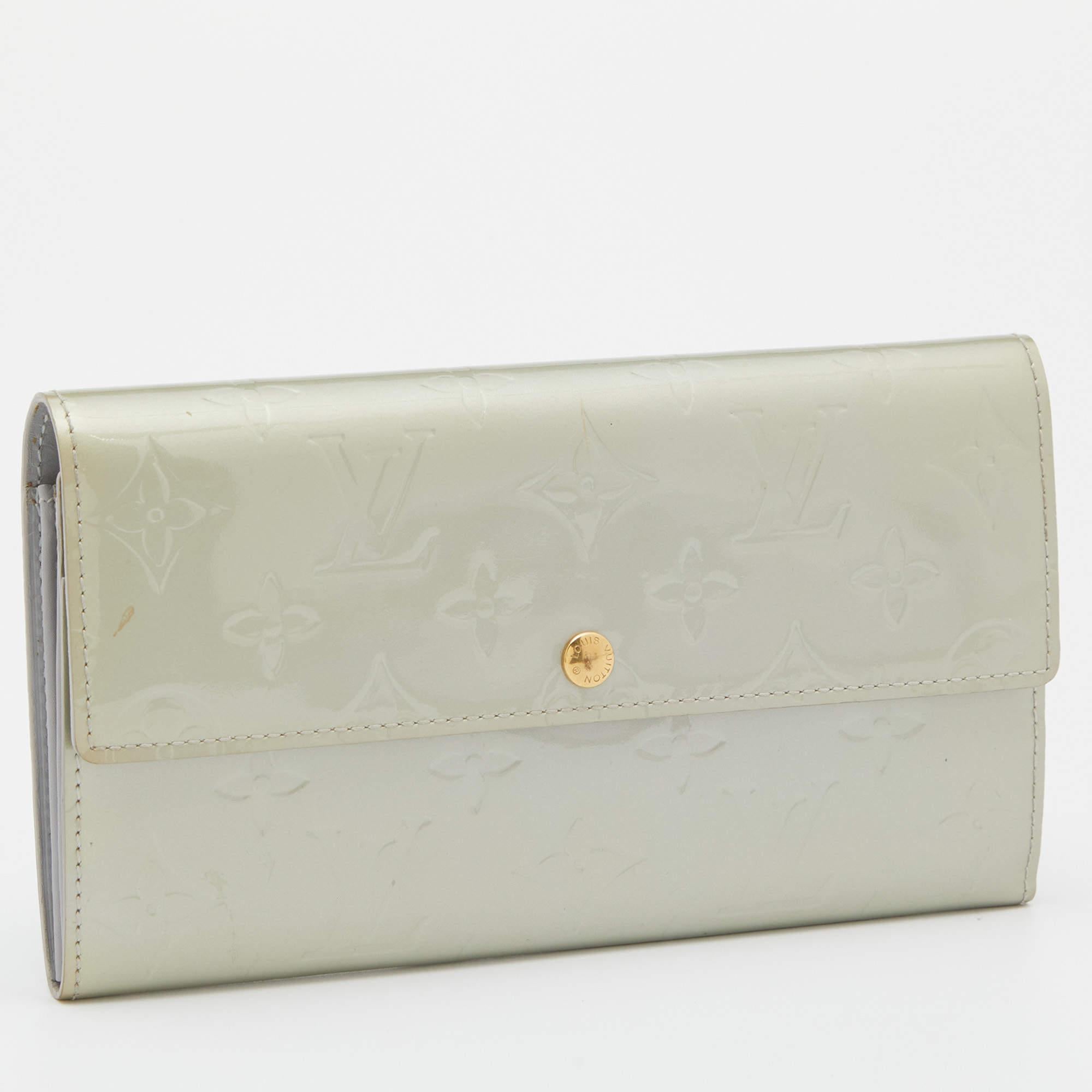 Uno degli accessori più amati e conosciuti della Maison Louis Vuitton è il portafoglio Sarah. È stata creata utilizzando Monogram Vernis all'esterno e sfoggia un bottone a pressione anteriore dorato.

