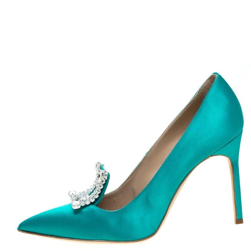 Walk with grace and confidence in these pumps by Manolo Blahnik. Styled as a point toe, with an elevated crystal embellishment, leather lining and padded insole, this turquoise satin pair will never fail to lift your outfits. Wear them with dresses