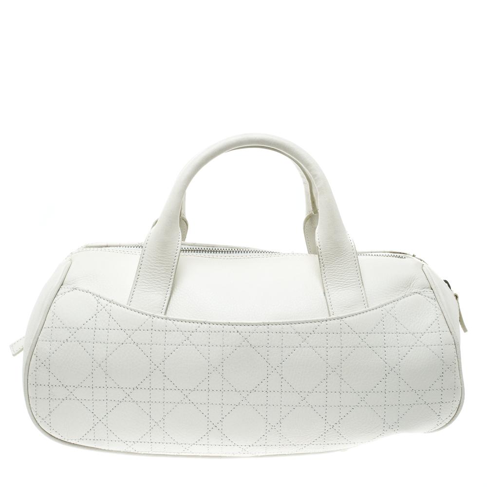 Striking in appeal and high on trend, this Boston bag by Dior is a buy you won't regret. Crafted from white leather in their signature Cannage pattern, the bag has a well-sized fabric interior and two top handles with D buckles. The piece is