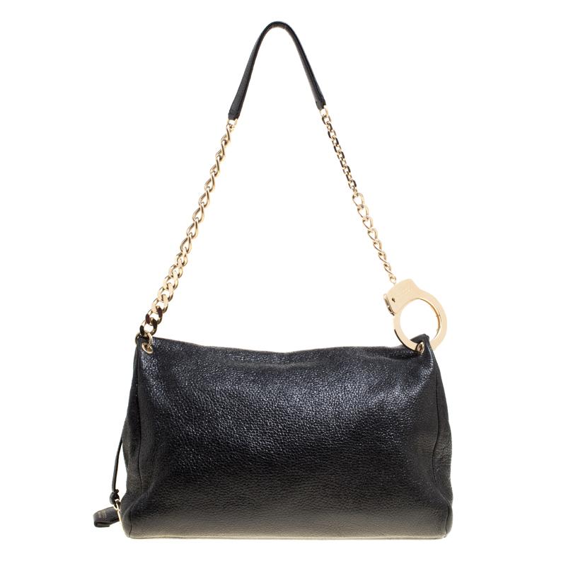Characterised by the golden handcuff, this Ally shoulder bag from Jimmy Choo is the best piece to flaunt your powerful style statement. It is crafted from shimmery black leather with an asymmetric front flap. The top zip closure opens to an