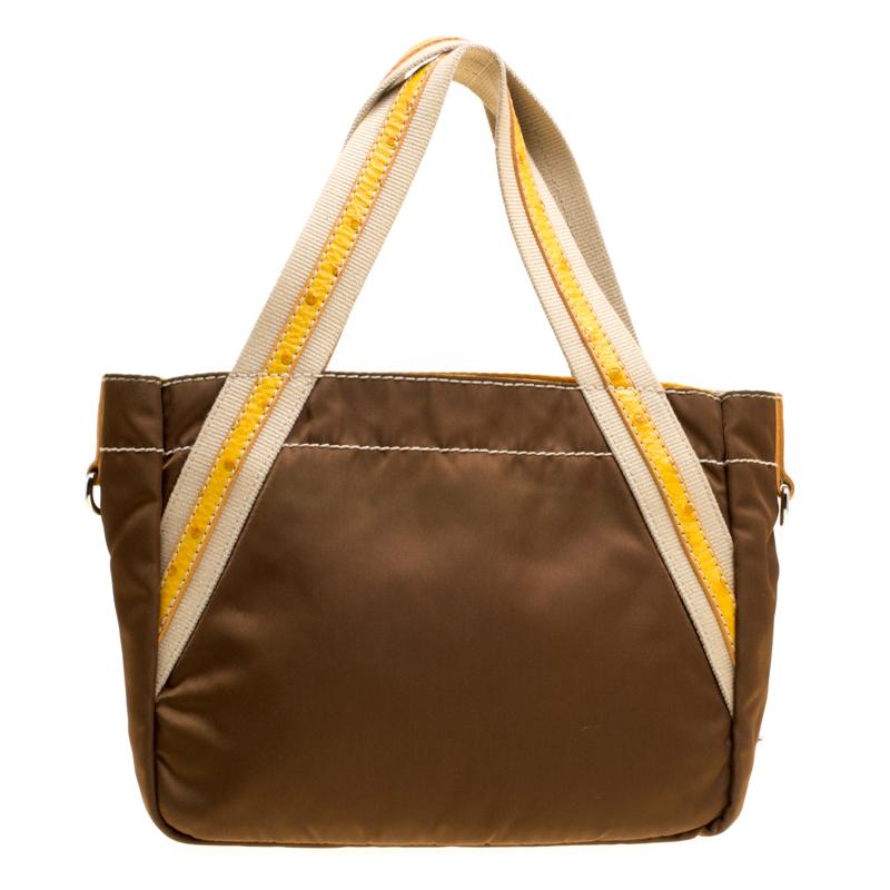 Created from nylon, this tote from Prada is reliable. It comes in brown with two top handles, two fun pin patches and a well-sized nylon interior. Made with love is this piece you must own.

Includes: The Luxury Closet Packaging


