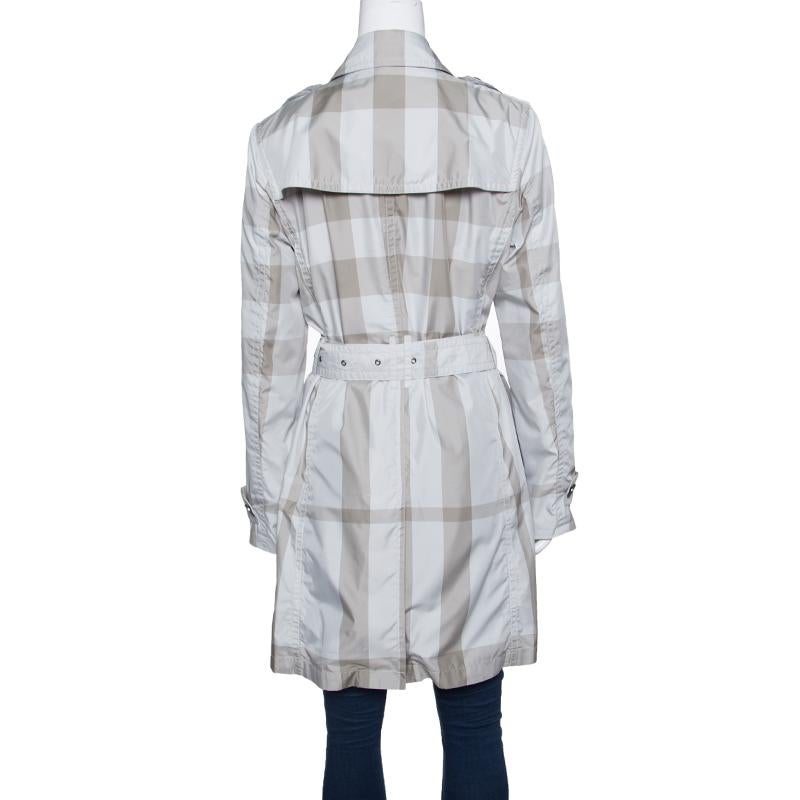 This Burberry trench coat will be a dream addition to any woman's closet. This creation is made from quality fabrics and it not only carries a well-tailored silhouette but also stylish details like the signature check and the double-breasted design.