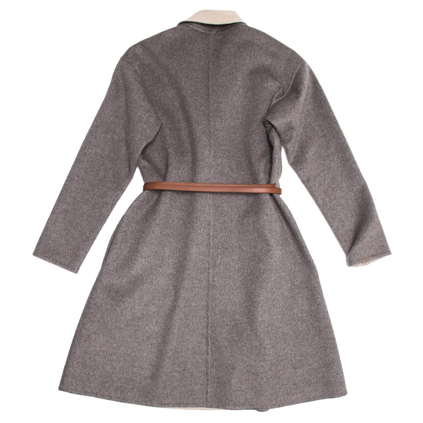 Cashmere A-line coat with heather grey outer layer, tan color lapel and inside layer. The finishing of the fabric is double face, which gives it a very clean and elegant look. A tan brown leather belt is to be wrapped around the waist and fastened