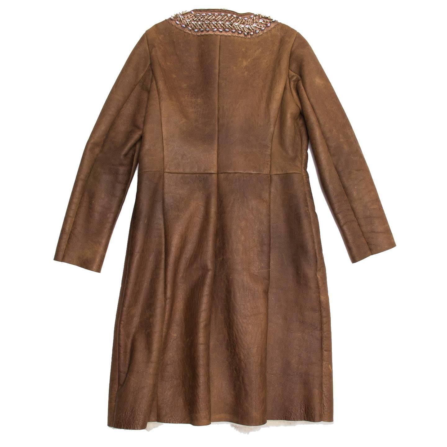 Toffee brown naturally distressed leather coat with shearling lining and mink fur trim down center front, single welt pockets at front. Hand stitched satin trim around neckline with beading and crystals.

Size  46 Italian sizing
Condition 