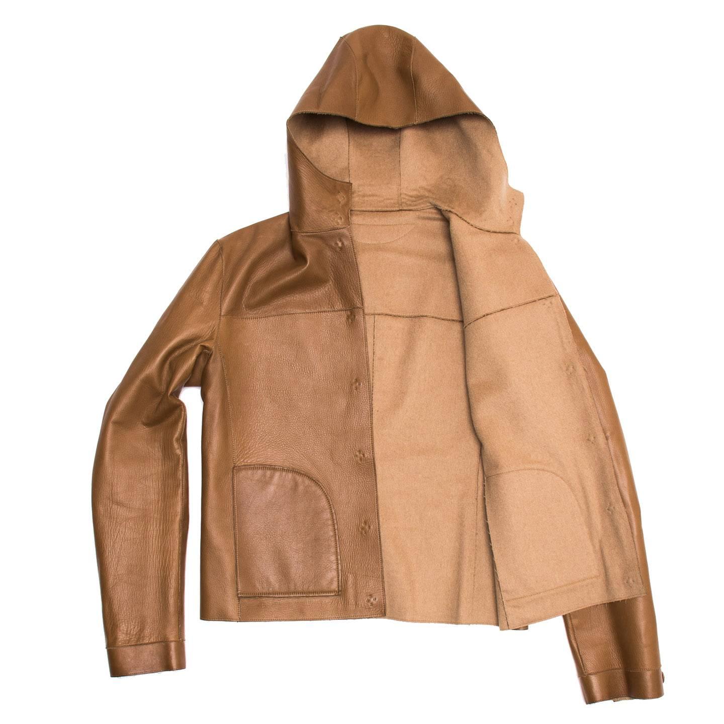 Camel cropped hooded jacket in a soft supple leather reversible to camel hair. Concealed snaps on camel hair side with inseam pockets. Single concealed snap at cuff. Made in Italy.

Size  44 Italian sizing

Condition  Excellent: worn a few times