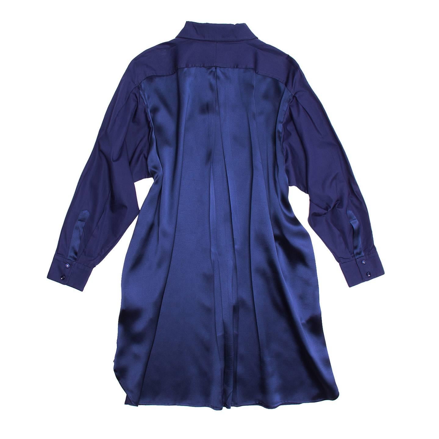 Royal blue drop shoulder long sleeve shirt and cotton dress. Silk rosettes covering buttons and silk strip running down center front placket. Buttoned down collar point detail. Buttoned cuffs with placket. Flowing silk backside panel. Self sash