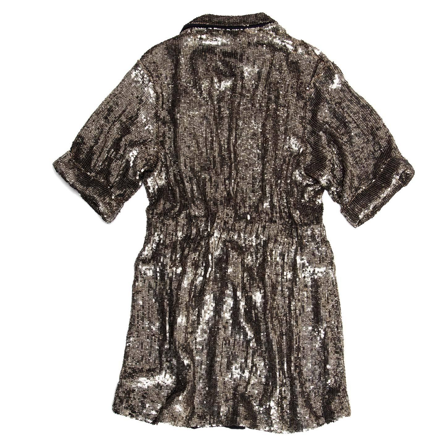 Stunning matt silver fully sequined dress coat with double breasted front closing, slightly gathered waist and short sleeves with turn-ups. The dress has a blazer collar with small lapel, flap pockets and it can be worn as a long jacket too. The