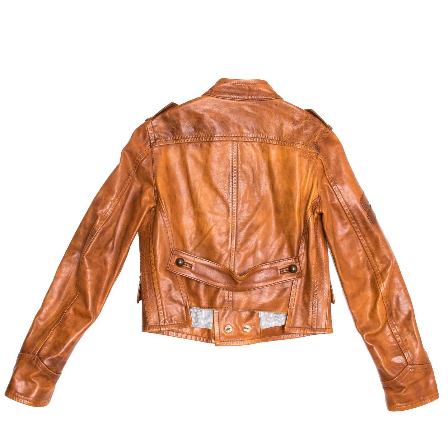 Burnt Sienna leather double breasted jacket with military detailing. Top stitched seams embellish the whole jacket, four shaped pockets flaps and bell dark bronze buttons enrich the front while a back buckle with buttons adorns the waist. The